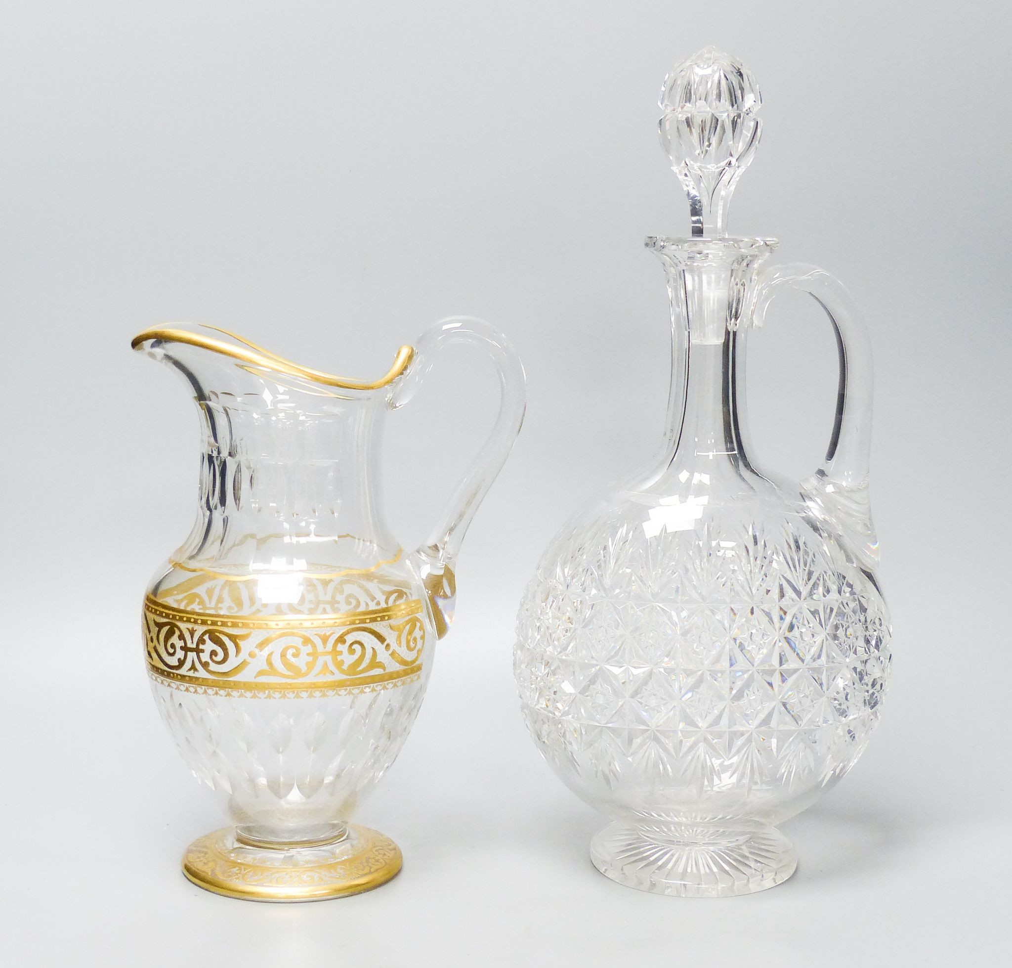 A Baccarat gilt and cut glass jug and a strawberry cut glass decanter and stopper, tallest 38 cm